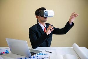 homme d & # 39; affaires travaillant avec un ordinateur portable et à l & # 39; aide de lunettes de réalité virtuelle photo