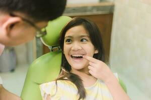 mignonne asain fille pendant dentaire traitement à moderne clinique photo
