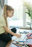 enfant fille dessin avec coloré des crayons photo