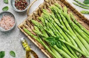 bouquet de tiges d'asperges crues avec différentes épices photo