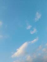 nuages blancs dans le ciel bleu. beau fond bleu clair. peu nuageux, beau temps. nuages bouclés par une journée ensoleillée. photo