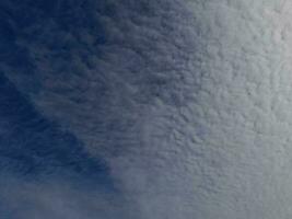 nuages blancs dans le ciel bleu. beau fond bleu clair. peu nuageux, beau temps. nuages bouclés par une journée ensoleillée. photo