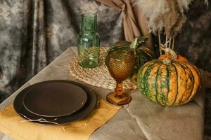 l'automne intérieur. une table couvert avec plats, citrouilles, une détendu composition de Japonais pampa herbe. intérieur dans le photo studio. proche - en haut de une décoré l'automne tableau.