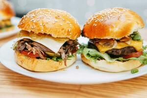 des hamburgers avec du boeuf et des légumes. proche en haut. délicieux des hamburgers dans une cuisine classe. Burger avec canneberge sauce et Burger avec oignon sauce. photo