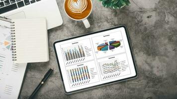 tablette avec graphiques et rapports sur le lieu de travail de bureau. vue de dessus mise à plat photo