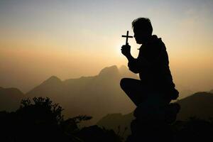 silhouette de homme prier pour dieux bénédictions avec le Puissance et Puissance de le sacré sur le Contexte de lever du soleil. le concept de Dieu et spiritualité. photo
