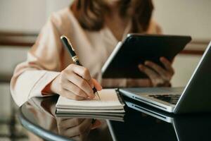 main de femme d'affaires travaillant avec un nouvel ordinateur moderne et écrivant sur le diagramme de stratégie du bloc-notes en tant que concept photo