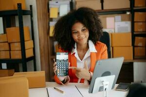 petite entreprise entrepreneur PME femme indépendante travaillant au bureau à domicile, boîte, tablette et ordinateur portable en ligne, marketing, emballage, livraison, concept de commerce électronique photo