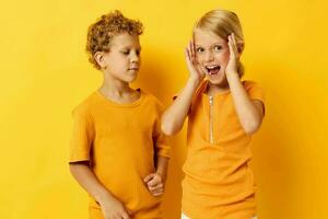 mignonne préscolaire des gamins dans Jaune t-shirts permanent côté par côté enfance émotions Jaune Contexte inchangé photo