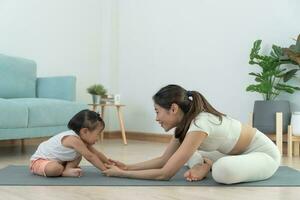 maman et fille pratiquant yoga ensemble dans pièce à maison. asiatique femme Faire des exercices dans Matin. équilibre, méditation, relaxation, calme, bien santé, content, se détendre, en bonne santé mode de vie, régime, svelte photo