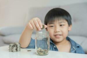 économiser de l'argent. les enfants mettent des pièces pour économiser. richesse, finance, assurance, investissement, éducation, avenir, planifier la vie, apprendre, banque, famille, santé, assurance maladie et accident. photo