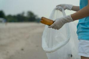 économiser l'eau. les volontaires ramassent les ordures à la plage et les bouteilles en plastique sont difficiles à décomposer pour éviter de nuire à la vie aquatique. terre, environnement, verdir la planète, réduire le réchauffement climatique, sauver le monde photo