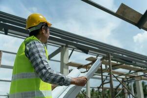 inspecteur ou ingénieur est inspecter construction et qualité assurance Nouveau maison en utilisant une bleu imprimer. ingénieur ou architectes ou contacteur travail à construire le maison avant remise il plus de à le propriétaire photo