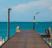 paysage été passerelle pont marcher mer et aussi petit port. et petit bateau amarré avec vue de bleu mer, clair ciel faire le ménage, adapté vacances Voyage à golfe Thaïlande Khao apprendre toi nationale parc rayong photo