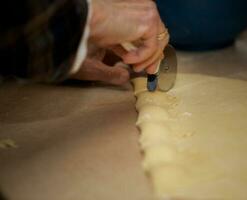 vieux femme est en train de préparer fait maison Ravioli avec fromage photo