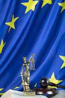statue de themis sur une drapeau de européen syndicat. photo