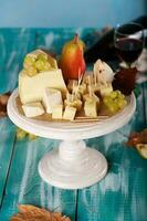 fromage tranches, poire, et les raisins sur une en bois rester. photo