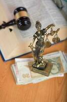 statue de themis sur une pile de billets de banque. fermer photo