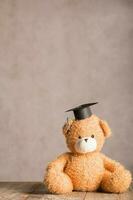 marron peluche nounours ours avec académique casquette sur le Haut. photo