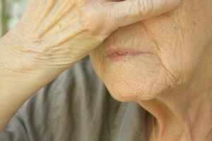 lèvres et une partie de une main de un vieux femme photo