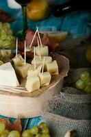 fromage tranches, poire, et les raisins sur une en bois rester. photo