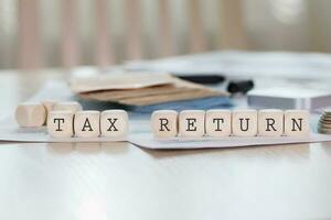 mot impôt revenir est composé de en bois des lettres. photo