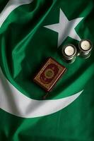 coran et bougies sur une drapeau de Pakistan. photo