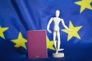 biométrique passeport et mannequin figurine dans de face aller UE drapeau. photo