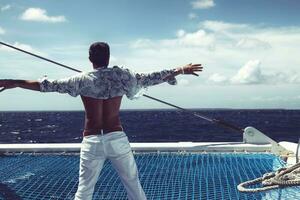 jeune homme naviguant sur son bateau en pleine mer photo