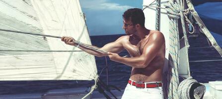 jeune homme naviguant sur son bateau en pleine mer photo