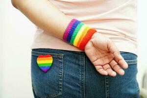 femme asiatique avec drapeau arc-en-ciel, droits des symboles lgbt et égalité des sexes, mois de la fierté lgbt en juin. photo