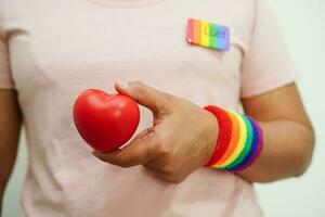 femme asiatique avec drapeau arc-en-ciel, droits des symboles lgbt et égalité des sexes, mois de la fierté lgbt en juin. photo