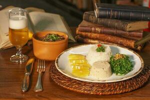 magnifique plat de feijoada avec bière. dans le Contexte vieux livres photo