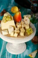 fromage tranches, poire, et les raisins sur une en bois rester. photo