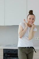 Jeune Dame séjours dans de face nouvellement installée cuisine photo