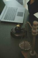 concept de justice et de droit. juge masculin dans une salle d'audience avec le marteau, travaillant avec, clavier d'ordinateur et d'accueil, lunettes, sur table à la lumière du matin photo