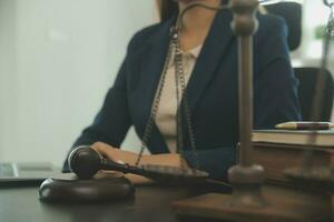 concept de justice et de droit. juge masculin dans une salle d'audience avec le marteau, travaillant avec, clavier d'ordinateur et d'accueil, lunettes, sur table à la lumière du matin photo