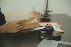 concept de justice et de droit. juge masculin dans une salle d'audience avec le marteau, travaillant avec, clavier d'ordinateur et d'accueil, lunettes, sur table à la lumière du matin photo