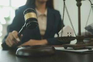 concept de justice et de droit. juge masculin dans une salle d'audience avec le marteau, travaillant avec, clavier d'ordinateur et d'accueil, lunettes, sur table à la lumière du matin photo