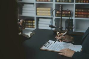 concept de justice et de droit. juge masculin dans une salle d'audience avec le marteau, travaillant avec, clavier d'ordinateur et d'accueil, lunettes, sur table à la lumière du matin photo