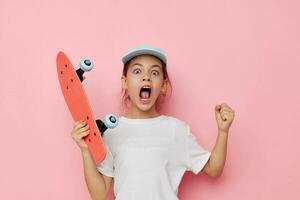 jolie Jeune fille casquette dans blanc T-shirt planche à roulette isolé Contexte photo