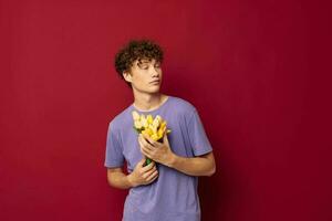 une Jeune homme rouge cheveux dans décontractée porter bouquet de fleurs cadeau rouge Contexte inchangé photo