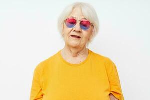 photo de retraité vieux Dame dans une Jaune T-shirt posant lumière Contexte