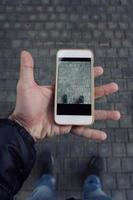 main avec un smartphone prenant des photos