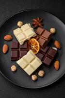 une mélanger de nombreuses les types de délicieux sucré Chocolat cassé dans cubes sur une noir assiette photo