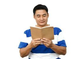 bel homme asiatique tient un livre à lire. concept, temps de détente, passe-temps, passe-temps. accordez-vous du temps pour lire des livres, des magazines, des romans. lecture au quotidien. l'éducation, la connaissance ou le plaisir. photo