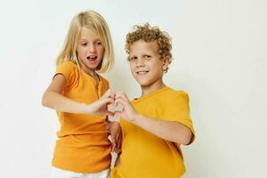 de bonne humeur garçon et fille dans Jaune t-shirts posant studio photo