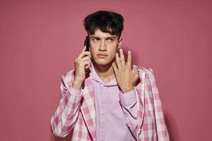 photo de romantique Jeune copain avec une téléphone dans main rose blazer mode élégant style mode de vie inchangé