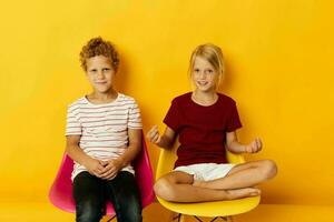 petit les enfants enfance séance sur chaises ensemble sur coloré Contexte photo