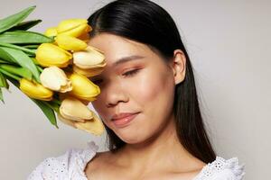 femme avec asiatique apparence romance bouquet de fleurs près le visage mode de vie inchangé photo